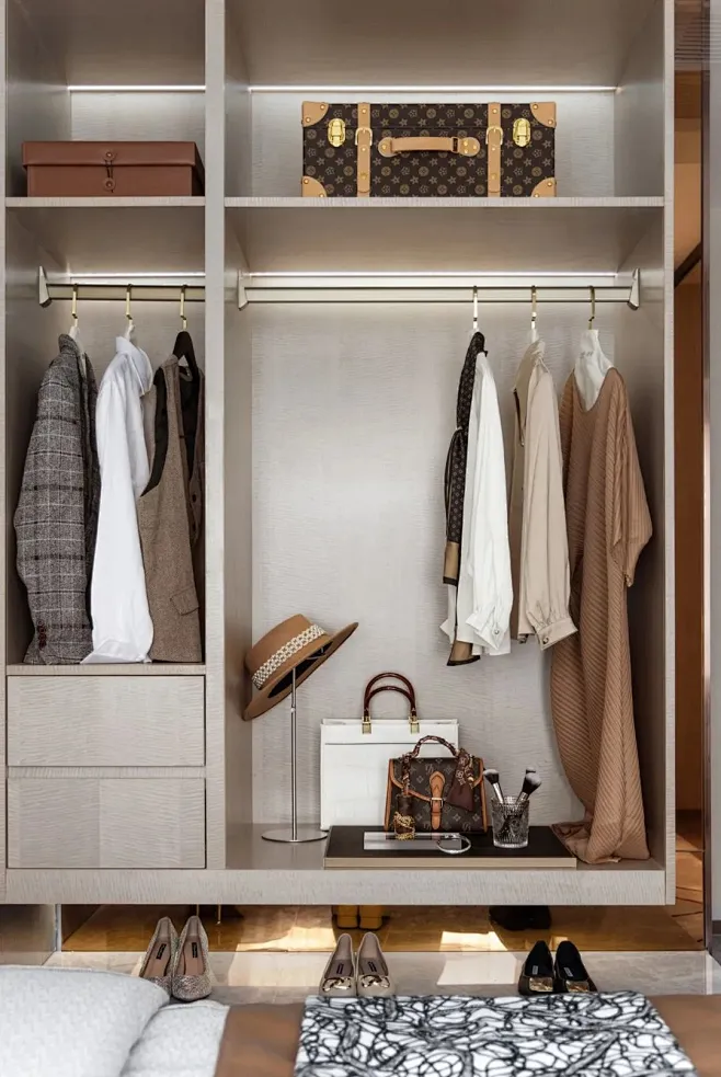 This may contain: an organized closet with clothes, shoes and handbags ...