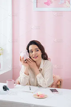 特写肖像快乐，微笑的女商人，抱着粉红色的储蓄罐
