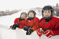Portrait of ice hockey players leaning on rink wall - stock photo