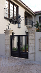 A classic and custom wrought iron entry gate, complimented by an accent arch, is an eye catching feature added to this Spanish style home.: