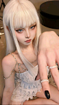 This may contain: a woman with long white hair and black nails