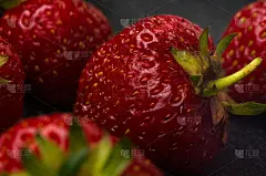 新鲜熟透的草莓放在黑色陶瓷盘子上