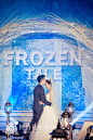 "Frozen Tale 冰雪童话“主题婚礼－怪兽花花出品 By @怪兽花花婚礼 : 整个婚礼布置采用冰蓝色、白色、银色搭配，树枝、冰山、雪地精灵等元素增添了童话乐趣和浪漫遐想。策划师把舞台打造成一个冰雪铸成的冰洞城堡，甜品区则构想成一个冰雪的童话世界，两个原创的雪地精灵围绕着一个“旋转木马式”的甜品台，桌子也设计成了矮桌，方便小朋友们自己动手拿甜品吃。