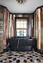 Designer Kelly Wearstler incorporated a mixture of luxurious materials in the master bathroom of Lara and Jeff Sanderson's Mercer Island, Washington, home. The walls are covered in onyx fantastico, and the flooring is marble and onyx; the sconces are vint
