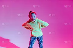 年轻时髦的女孩在彩色霓虹灯背景下在工作室跳舞。音乐dj海报设计。