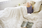 Blonde woman sleeping in a bed with white linen. by Mint Images on 500px