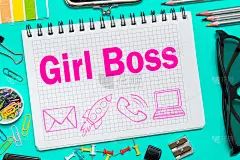 女老板记在办公室桌上的笔记本上。企业女孩的概念