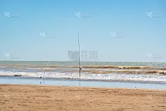 把鱼竿刺在沙上，等鱼上钩