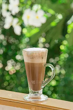 木质背景上白色杯子上的咖啡图案