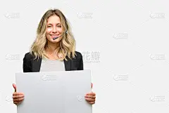 来自呼叫中心的年轻女接线员手持空白广告横幅，好的广告海报，报价或公告，大的纸广告牌