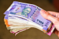 Woman's hands holding brand new indian 100, 200, 500, 2000 rupees banknotes.