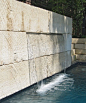 modern stone pool wall water feature and fountain using large stone slabs and a sheer descent waterfall. ohlenburg inc. swimming pool design - dallas, texas