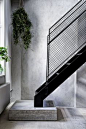 Minimalistic staircase with metal handrail and concrete flooring.