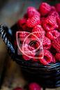 Raspberries in a basket on rustic wooden background #水果#