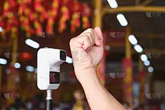 在新冠肺炎疫情期间，在华人寺庙内使用红外数字体温计进行体温扫描