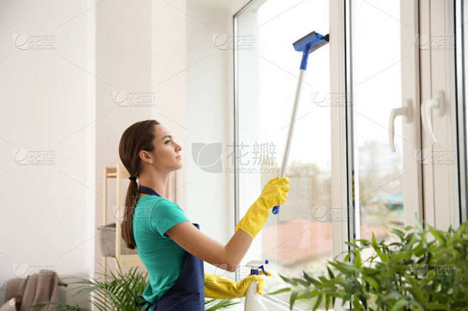 女性看门人清洁窗口在平