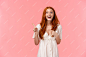 young redhead girl with happy expression pointing to something