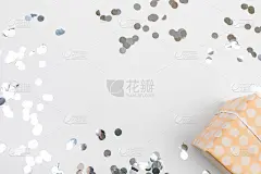 礼物或礼品盒银色的纸屑在白色的桌面视图。生日，圣诞节或婚礼的平铺作文。