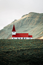 This may contain: a red and white church on top of a hill