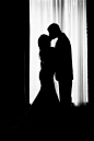 Silhouette of Groom and Bride Kissing Near Window