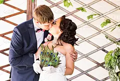 新婚夫妇亲吻，新娘子捧着孔雀羽毛扇，欢天喜地
