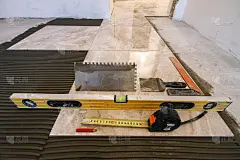 瓷砖和瓦工工具。地砖安装。家居装修、翻新——瓷砖地坪胶粘剂、抹子用灰浆、水平尺、卷尺