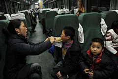1月10日，K1159次烟台—广州的列车上，妈妈在给周穗成喂饭。周穗成，7岁，爸爸在广州打工，小家伙一直跟着妈妈在老家长沙。这次踏上K1159次列车是为了和孤军奋战在广州的爸爸一起过年。 CFP