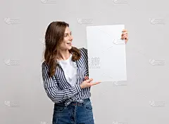 年轻女子兴奋地看着她手中的白纸