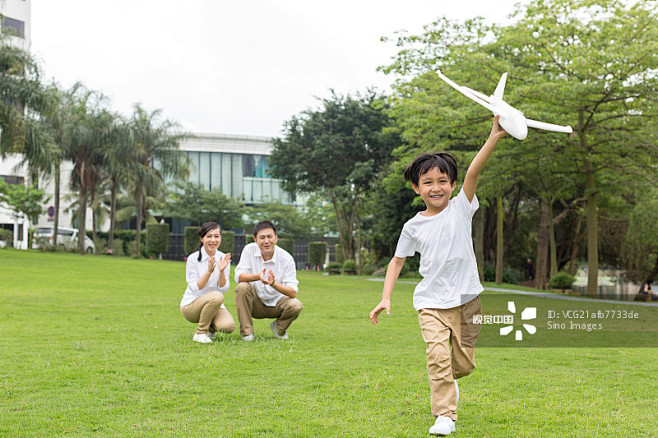 快乐的一家人在公园玩飞机模型