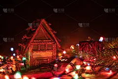 美丽，神奇的圣诞背景，贺卡。小房子站在一个木制的背景之间的圣诞彩灯特写，在背景一个黑色的背景与复制空