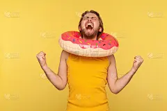 情绪极为激动的快乐游客小伙站在汗衫上，用粉色甜甜圈圈住了脑袋