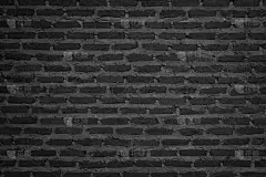 墙面为深色砖墙纹理背景。砖砌或石砌地板室内岩石旧图案干净混凝土网格不均匀砖设计堆叠。