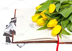 黄色郁金香和黑白照片躺在书上