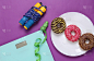 减肥的概念。盘子里的高热量甜甜圈、天平和紫色背景下的跳绳
