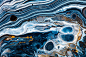 流体艺术纹理。背景与抽象漩涡油漆效果。液体丙烯酸画与美丽的混合油漆。可用于室内海报。黑色，蓝色和金色