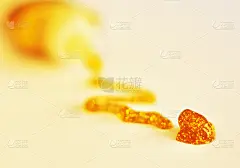 特写的斑点的黄金闪光胶水在白纸上与之之字的轨迹导致管容器在背景中失去焦点