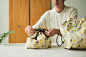 束口旅行衣物袋 M : 印花樂是台灣的原創印花布設計品牌，擅長以繽紛的印花風格，創造出各種美麗實用的生活商品。<br />
首度結合台灣知名插畫家、生活風格家米力的繪畫元素，以台灣為靈感，描繪原生種的黃色相思樹、大稻埕的生活物件…<br />
溫柔感性的插畫線條，呈現出故事般的印花氛圍。<br />
系列商品涵蓋居家裝飾、洋裝圍裙、帽子、髮飾…，等多樣生活實用設計。<br />
透過印花樂的商品詮釋，巧妙融合米力插畫中的大人品味，牽引出淡淡的少女氣息。<