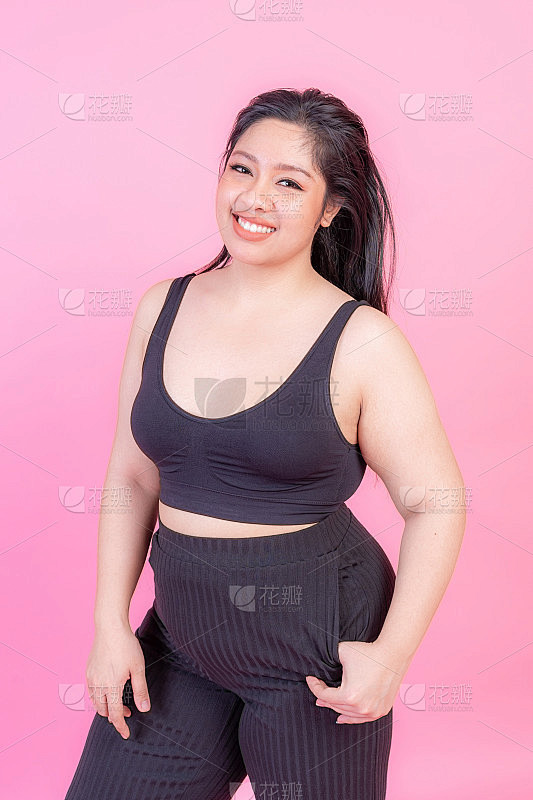 肖像美丽丰满的年轻女子微笑在粉红色的背景，加上尺寸时装模特身体积极的概念素材-花瓣网