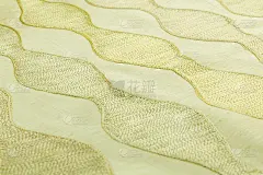 黄色背景的豪华布料或波浪褶皱的垃圾丝绸质地的缎子天鹅绒