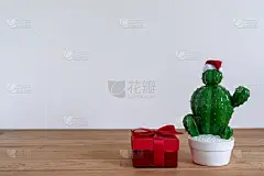 圣诞装饰品和新年装饰品概念的配件。仙人掌花盆与红色礼盒对象派对季节在现代乡村的棕色和灰色的石头背景。