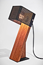 OBLIC TABLE LAMP : This table lamp is handcrafted from contrasting materials: the heavy base is made from a thick piece of hard wood, and it's light and delicate perforated shade has been folded from a thin piece of acrylic. The light enhances the rich wo