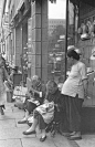 一家高档礼帽店外的街头缝纫摊贩，上海1949年。