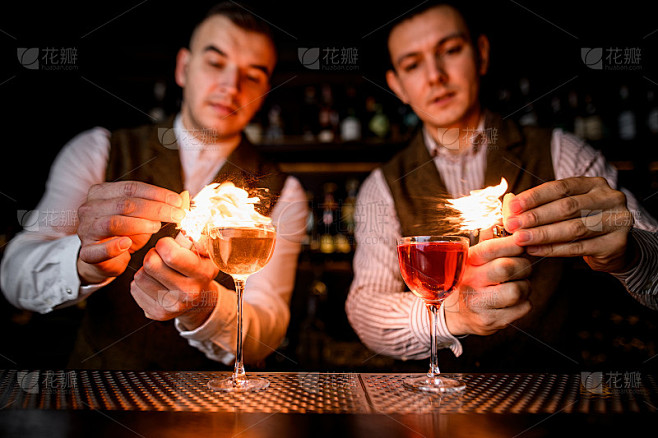 吧台上放着酒杯，专业的调酒师会洒上酒杯，然后点火
