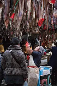 大连人入冬有吃咸鱼饼子的习惯，晒鱼也就成了市场里一道独特的风景。鱼身上大都挂着一个10厘米长、5厘米宽的红布条，上面写着买鱼人的姓名和电话,这样买鱼人就可以放心晾晒，不用担心被“掉包”了 作者王嘉慧