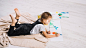 Cute little girl painting with bright aquarelle on floor