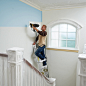 This may contain: a man on a ladder painting the walls