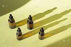 俯视图随机站立模型与滴管盖的瓶子在绿色背景，在阳光的射线，投射在表面上的阴影。美容行业理念，身体护理