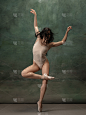年轻优雅温柔的芭蕾舞女演员在深绿色的工作室背景