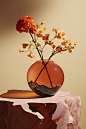 a vase of flowers sits on top of a stone base on a wooden table, in the style of conceptual minimalism, valentine penrose, ren hang, crystalline and geological forms, contrasting shadows, mars ravelo, matte photo