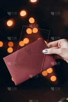 女性手握美甲卡为文字，背景为散景。选择性对焦，胶片和颗粒照片